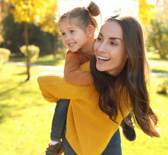 Mother and Daughter in Park Smiling